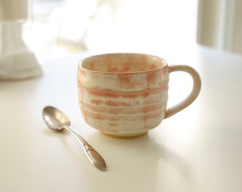 Ceramic tea or coffee cup, mug, handmade, textured surface of peach & cream, thrown on the potters wheel.