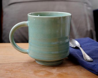 Handmade, ceramic coffee mug or teacup with celadon green glaze.