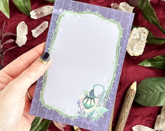 May include: A rectangular stationery sheet with a purple background featuring a vertical vine pattern. The center has a light purple rectangular area framed by green vines and small white stars. A glowing green lantern sits at the bottom right.