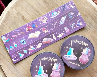 May include: Two circular rolls of washi tape and a flat strip of the same tape featuring a dark purple background with illustrations of potion bottles, books, quills, and paint palettes. The text Art Mage and Dread Pirate Bri is printed on the rolls.