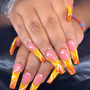 Abstrakta gula och orangea Gel-X-press-ons med fransk spets