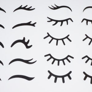 Könnte beinhalten: Eine Sammlung schwarzer, stilisierter Wimpern- und Augenbrauen-Designs auf weißem Hintergrund. Das Bild zeigt verschiedene Formen und Größen von Wimpern und Augenbrauen, geeignet für Bastel- oder Designprojekte.