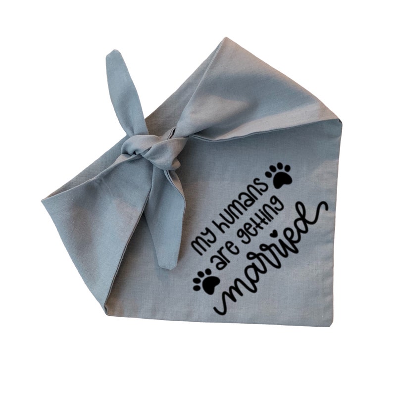May include: A light blue dog bandana with black paw prints and the text "My humans are getting married".