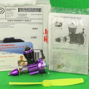 May include: A purple Cox Black Widow model engine with a silver cylinder head, a yellow plastic propeller, a printed instruction manual, and a business card from Jenuine Motor Productions, all packaged in a USPS Priority Mail cardboard box.