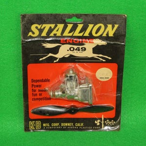 May include: A Stallion .049 cubic inch displacement model engine in original packaging. The black and red card features a horse graphic, the text 'Dependable Power for model fun or competition', and a black propeller. K&B Mfg. Corp. branding is visible.