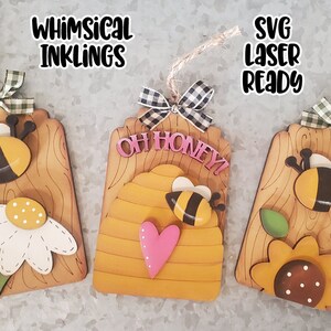 May include: Three wooden bee-themed tags with a woodgrain background. The first tag features a bee and a daisy. The second tag features a beehive with a heart and the text "Oh Honey!" The third tag features a bee and a sunflower. All tags have a black and white checkered ribbon.