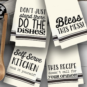 May include: Four white kitchen towels with black text and black stripes. The towels have the following text: "Don't just stand there do the dishes!" "Bless this mess!" "Self serve kitchen cook it yourself!" "This recipe doesn't call for your opinion!"