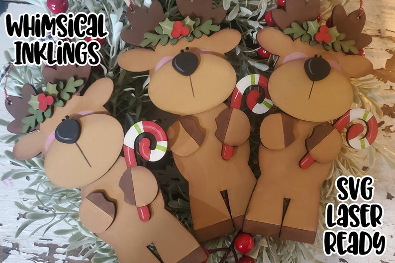 May include: Three wooden reindeer ornaments with candy canes in their hands. Each reindeer has a red nose, brown antlers, and a green holly wreath around its neck. The ornaments are laser cut and ready to be assembled.  SVG Laser Ready.