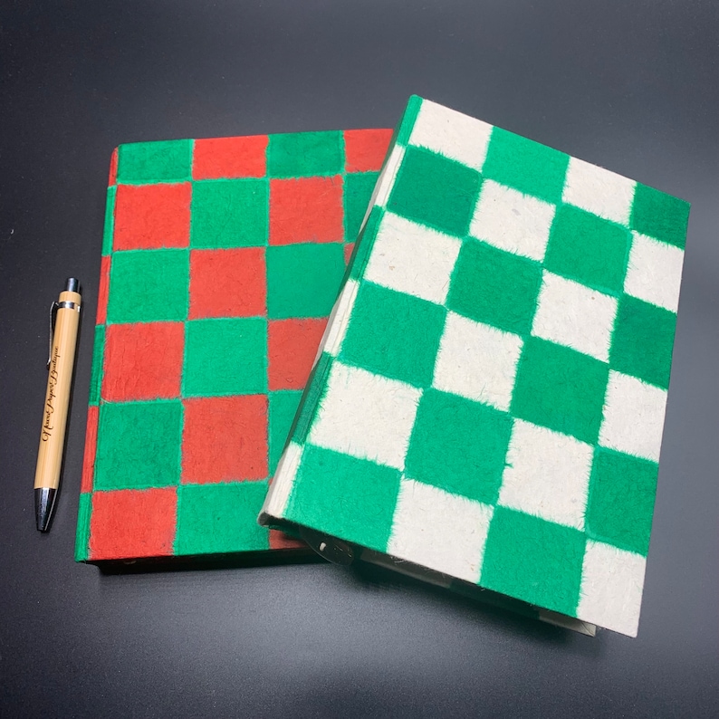 K&ouml;nnte beinhalten: Zwei Notizb&uuml;cher mit karierten Umschl&auml;gen. Ein Notizbuch hat rote und gr&uuml;ne Quadrate, das andere gr&uuml;ne und wei&szlig;e Quadrate.