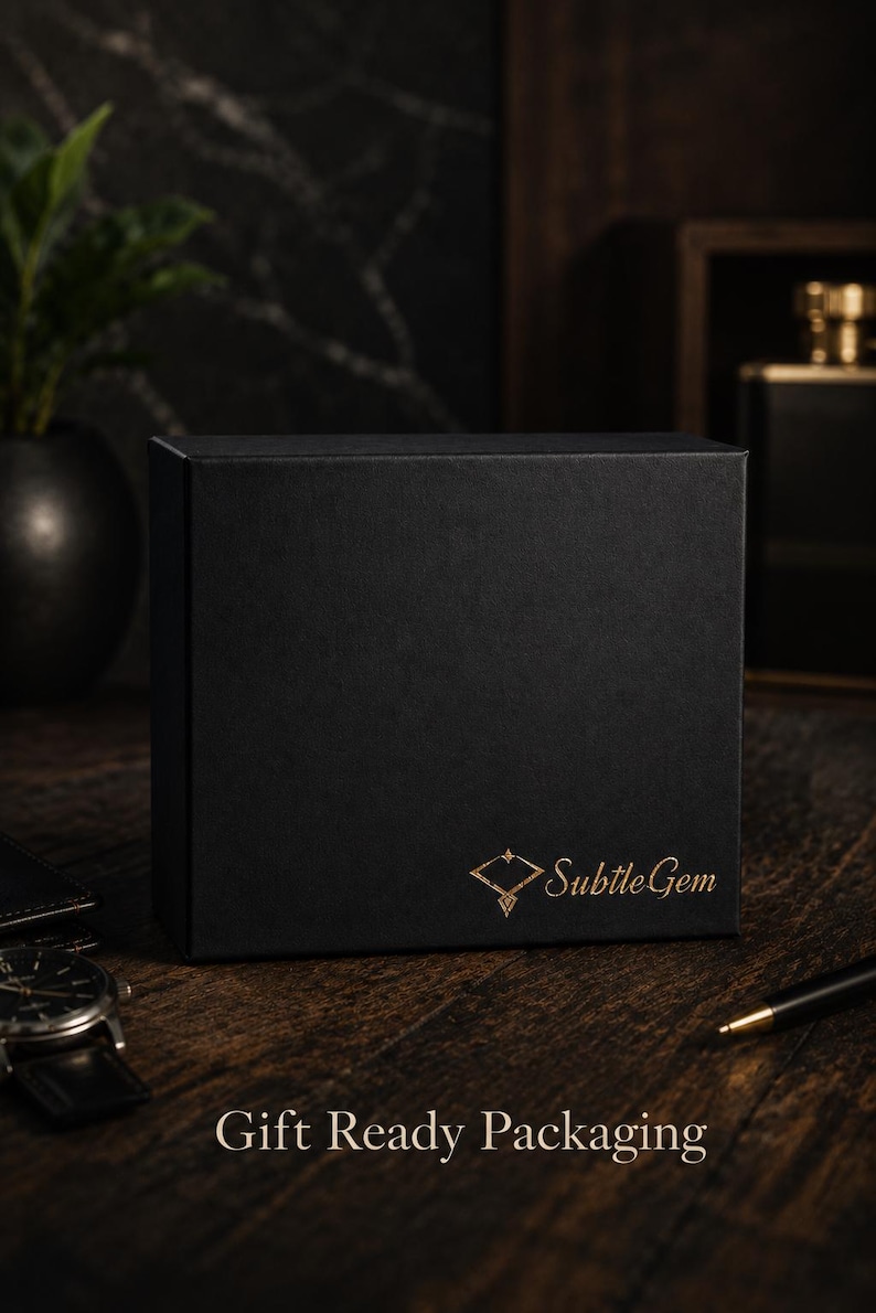 May include: A rectangular black gift box featuring the gold-colored text SubtleGem and a diamond-shaped logo on the front. The text Gift Ready Packaging is printed in gold at the bottom. The box has a smooth matte finish and a structured design.
