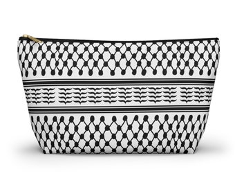 May include: A black and white zippered pouch with a geometric pattern. The pattern features a repeating design of black circles and lines on a white background.