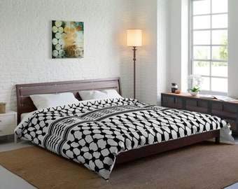May include: A black and white patterned duvet cover with a geometric design. The duvet cover is on a bed with a brown wooden frame and is in a bedroom setting.