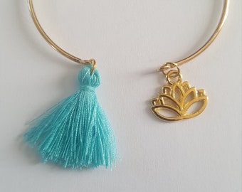 Golden bangle bracelet, its turquoise pompom and its lotus charm