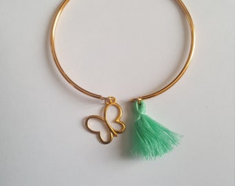 Golden bangle bracelet, its pastel green pompom and its butterfly charm