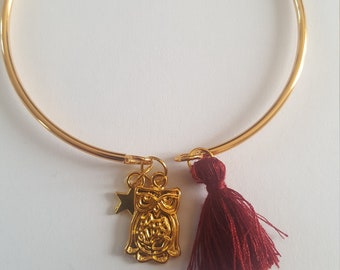Golden bangle bracelet, its Bordeaux pompom, its owl/star charm