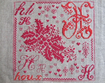 Red embroidery H as holly at the cross point