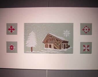 Painting of a snowy cottage and snowflakes