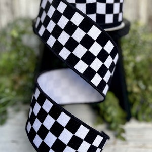 May include: Black and white checkered ribbon with a velvety texture. The ribbon is 2.5 inches wide and is perfect for adding a touch of racing style to your crafts.