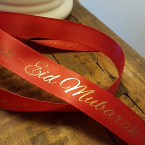 May include: Red satin ribbon with gold lettering that reads "Eid Mubarak".