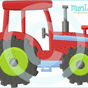 Könnte beinhalten: Roter Spielzeugtraktor mit schwarzen Rädern und grünen Reifen. Der Traktor hat einen blauen Streifen an der Seite.