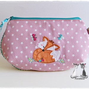 May include: A pink zippered pouch with a white star pattern. The pouch features an embroidered fox with orange fur and a white tail. There are also embroidered butterflies and flowers.
