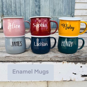 May include: Six enamel mugs with different names on them. The mugs are in the colours pink, red, yellow, grey, blue, and green. The mugs are arranged in two rows of three. The text "Enamel Mugs" is written below the mugs.