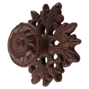 Może przedstawiać: Gałka drzwiowa z żeliwa z ozdobnym wzorem kwiatowym. Gałka jest ciemnobrązowa z rustykalnym wykończeniem.