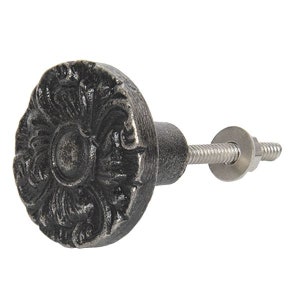 Könnte beinhalten: Ein schwarzer Schrank-Knopf aus Gusseisen mit einem detaillierten Blumenmuster. Der Knopf hat eine silberne Schraube und Unterlegscheibe.