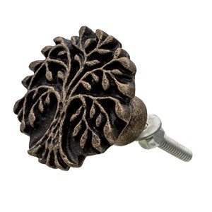 Könnte beinhalten: Ein Schrankknopf aus Gusseisen mit einem Lebensbaum-Motiv. Der Knopf ist in einem dunklen Bronze-Ton gehalten und hat eine Schraube zum Befestigen an einer Schranktür.