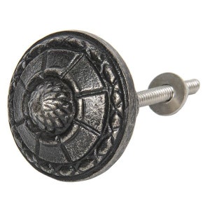 Può includere: Un pomello per armadio in metallo argentato con un design circolare dettagliato. Il pomello ha una vite filettata per il fissaggio a una porta dell'armadio.