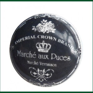 Può includere: Un pomello in ceramica nero e bianco con una corona e il testo "Imperial Crown Brand Marché aux Puces Marché Vernaison".
