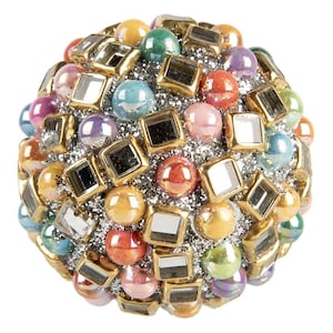 Puede incluir: Una esfera decorativa cubierta con una mezcla de cuentas de vidrio coloridas e iridiscentes y baldosas cuadradas espejadas. La esfera está adornada con detalles metálicos dorados y purpurina plateada, creando un diseño festivo y llamativo.