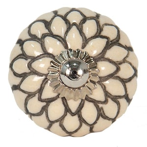 Peut inclure: Bouton de porte en céramique blanche avec un motif floral noir et un centre en métal argenté.