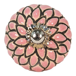 Może przedstawiać: Różowy ceramiczny gałka z czarnym wzorem kwiatowym i srebrno-złotym środkiem.
