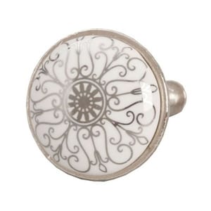 May include: A round cabinet knob with a white face featuring a silver, ornate floral design. The knob has a silver metal rim and a silver stem for attachment. The design is symmetrical and detailed.
