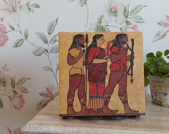 May include: A hand-painted wooden box featuring a scene of three figures in red, yellow and blue clothing. The figures are standing in front of a yellow background.