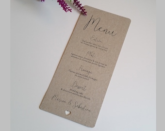 Può includere: Un menu di carta marrone con un ritaglio a forma di cuore. Il menu è scritto in francese e include i seguenti elementi: Estree, Plat, Franage, Dessert. Il menu è per un matrimonio e include i nomi Marion & Sebastien.