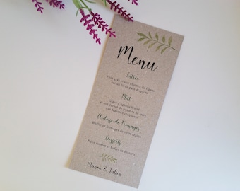 Può includere: Un menu in carta marrone con foglie verdi e il testo "Menu" in corsivo nero. Il menu elenca i seguenti articoli: Entree, Foie gras et son chutney de figues sur un lit de pain d'épices, Plat, Gigot d'agneau braisé et son écrasé de pommes de terre aux légumes croquants, Ardoise de Fromages, Buffet de fromages de notre région, Desserts, Piece montée et buffet de desserts. La parte inferiore del menu ha il testo "Manon & Julien" in corsivo nero.