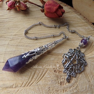 May include: Amethyst pendulum with a silver chain and a pentagram charm. The pendulum is a pointed crystal with a silver setting. The pentagram charm is ornate and has a silver finish.