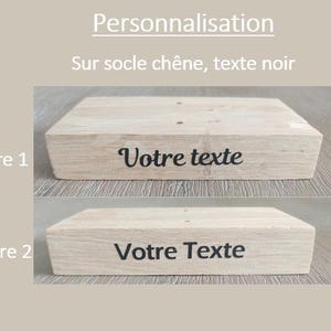 May include: Two examples of text engraving on a wooden base. The first example shows the text "Votre texte" in a cursive font. The second example shows the text "Votre Texte" in a more blocky font.