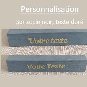 May include: Two close-up images of a dark gray rectangular block with a gold inscription. The top image shows the text "Votre texte" in a cursive font. The bottom image shows the text "Votre Texte" in a block font.