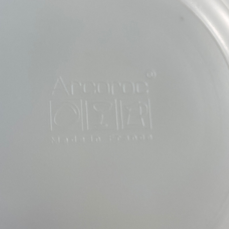 以下が含まれることがあります： 底に「Anchor Hocking」と「Made in USA」の文字が刻印された白いプラスチック容器です。