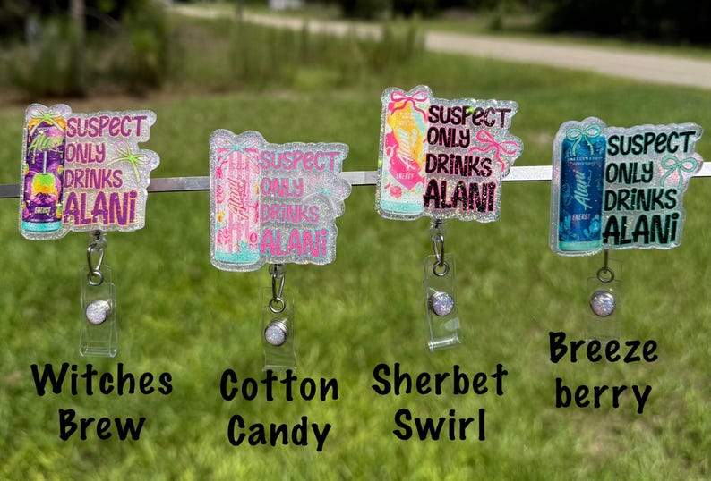 Pu&ograve; includere: Quattro porta badge con accenti glitterati, ognuno con un design a lattina e la scritta "SUSPECT ONLY DRINKS ALANI". I porta badge sono etichettati "Witches Brew", "Cotton Candy", "Sherbet Swirl" e "Breeze Berry".