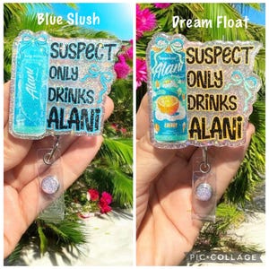 Pu&ograve; includere: Due porta badge con dettagli glitterati. Uno dice "Blue Slush" e presenta un design di bevanda blu con il testo "SUSPECT ONLY DRINKS ALANI". L'altro dice "Dream Float" e presenta un design di bevanda arancione con lo stesso testo.