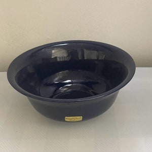 May include: A large, deep blue ceramic bowl with a glossy finish. The bowl has a slightly rounded bottom and a wide rim. The bowl is made by the company "Hagen Floral".