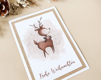 Christmas card in watercolor design with fawn and poinsettia