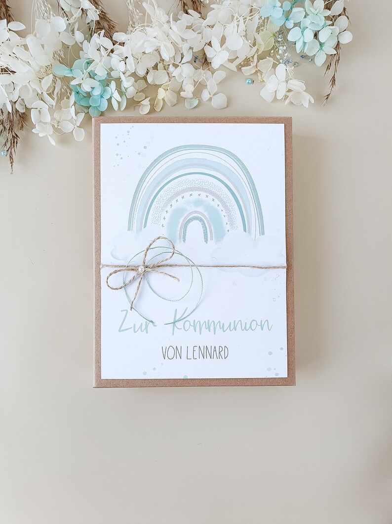 May include: A card with a watercolor rainbow design and the text "Zur Kommunion von Lennard".