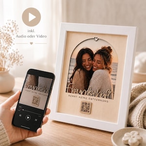 Könnte beinhalten: Weißer Fotorahmen mit einem Bild von zwei lächelnden Frauen. Der Rahmen trägt das deutsche Wort "Freundschaft" und den Satz "kennt keine Entfernung" aus Holz geschnitten. Ein Smartphone zeigt denselben Text und einen QR-Code.
