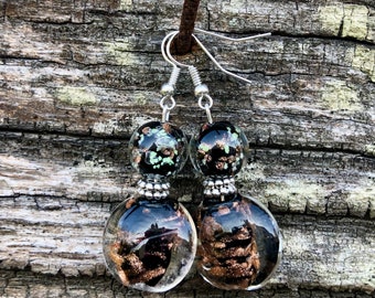 Boucles d’oreilles pendantes de couleur argent avec perle en verre transparente et noire aux reflets mordorées