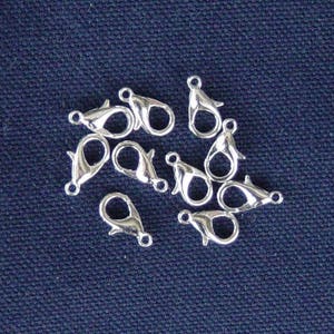 Peut inclure: Un groupe de dix fermoirs à ressort argentés, un type de composant de bijoux utilisé pour attacher des chaînes ou des cordons à des bijoux.